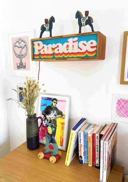 Illuminated light box, cyan and orange, retro 'Paradise' layered typography in wooden frame