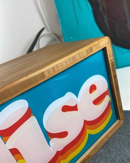 Illuminated light box, cyan and orange, retro 'Paradise' layered typography in wooden frame